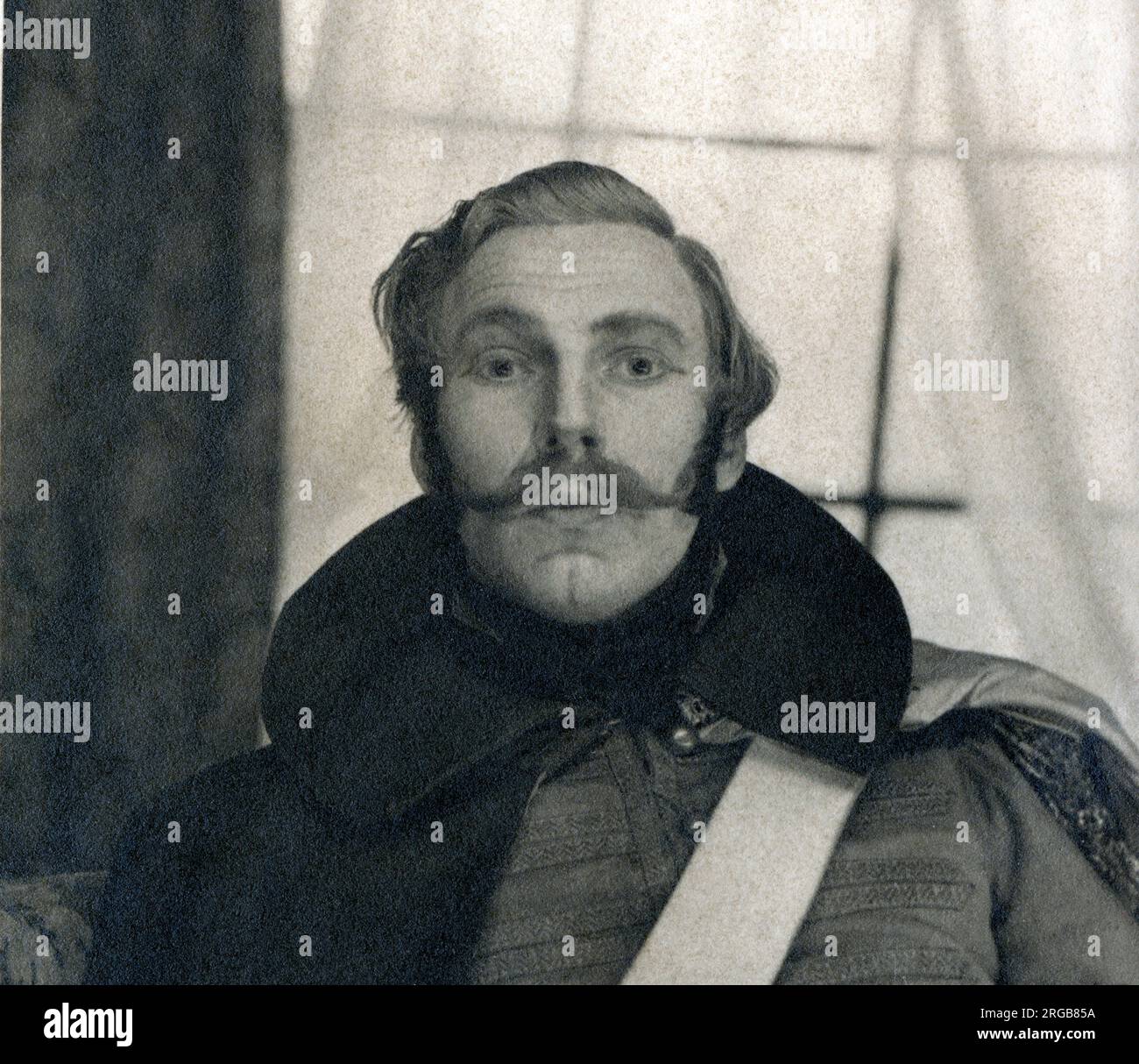 An unnamed actor in early to mid 19th century military costume poses for a studio photograph. The photograph was taken in late November, so possibly he was about to appear in a Christmas show/pantomime? Stock Photo