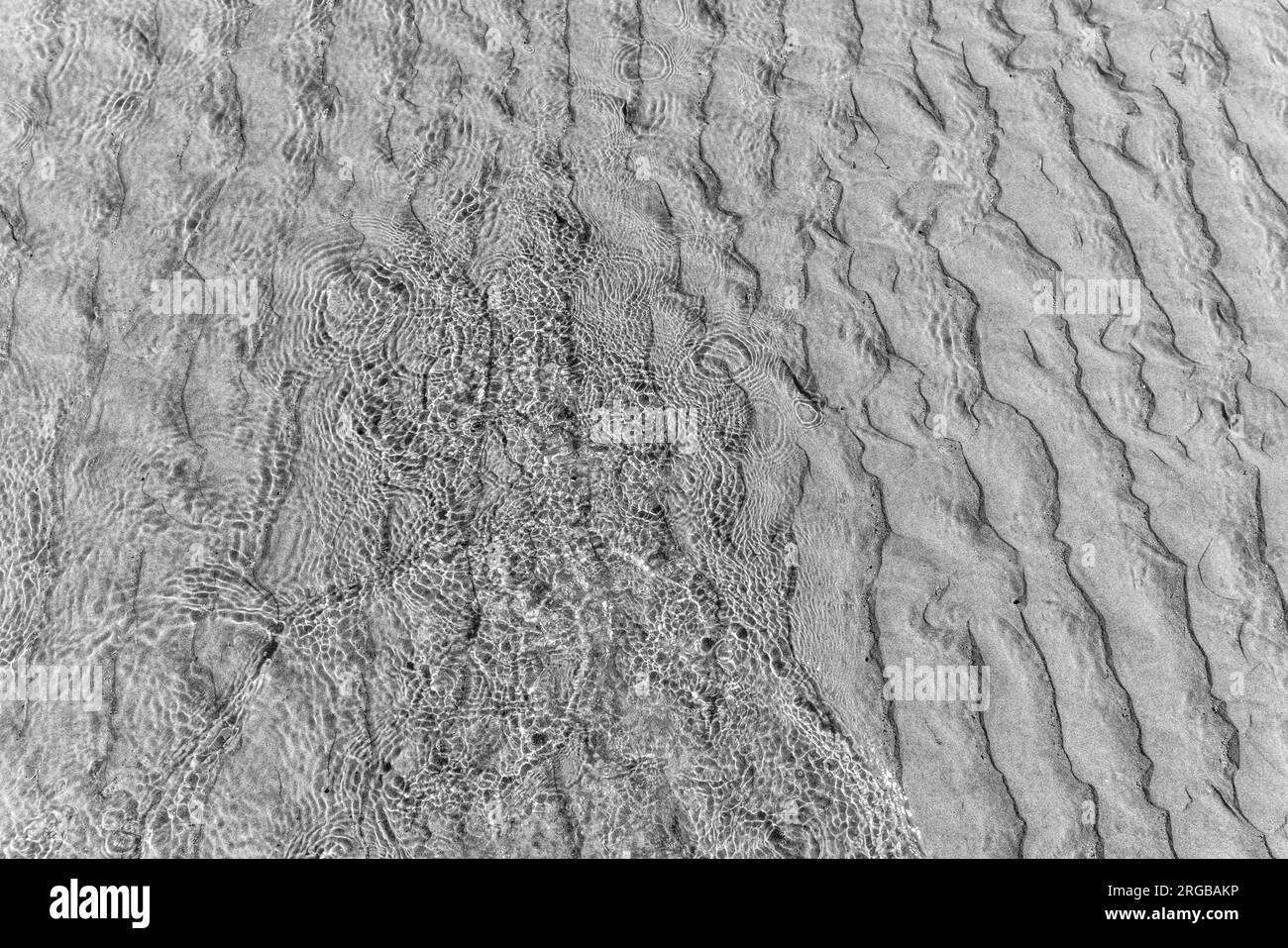 Ocean water forms patterns over sand as it reaches shore in Moclips ...