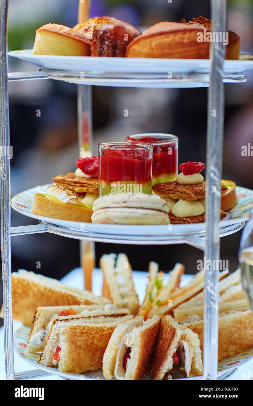 Selection of sandwiches and fancy cakes served for the ceremony of afternoon tea on a cakestand