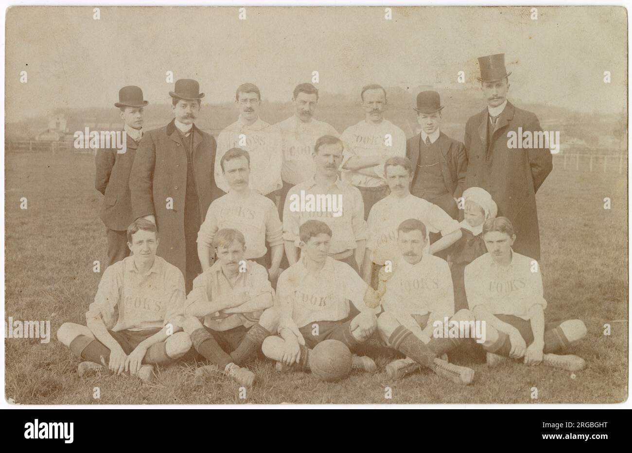 Cook's Football Team, unknown location, group photo on a sports ground with four well-dressed men and a child. Stock Photo