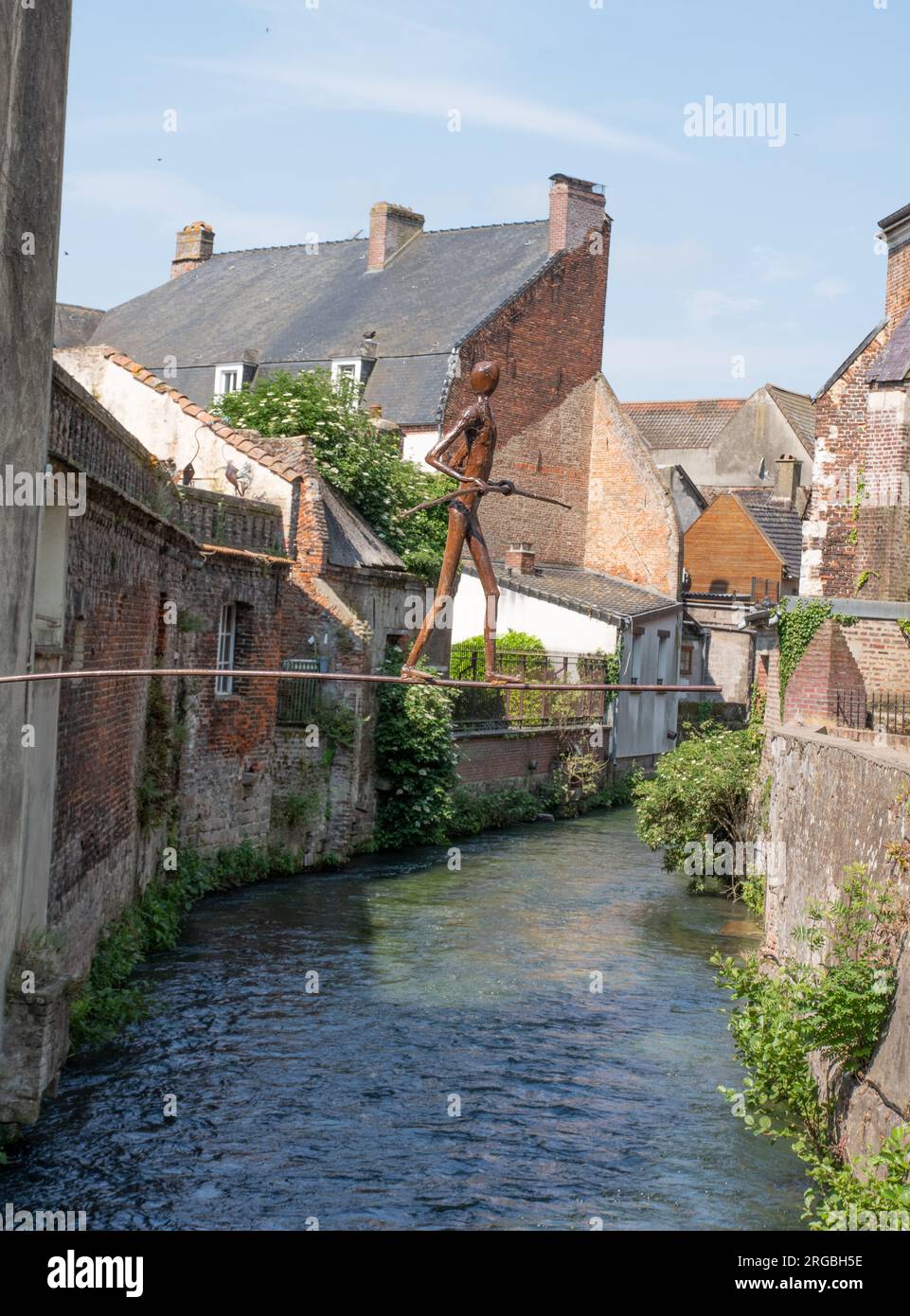 Tightrope walker metal sculpture over the river Canche in Hesdin Stock Photo