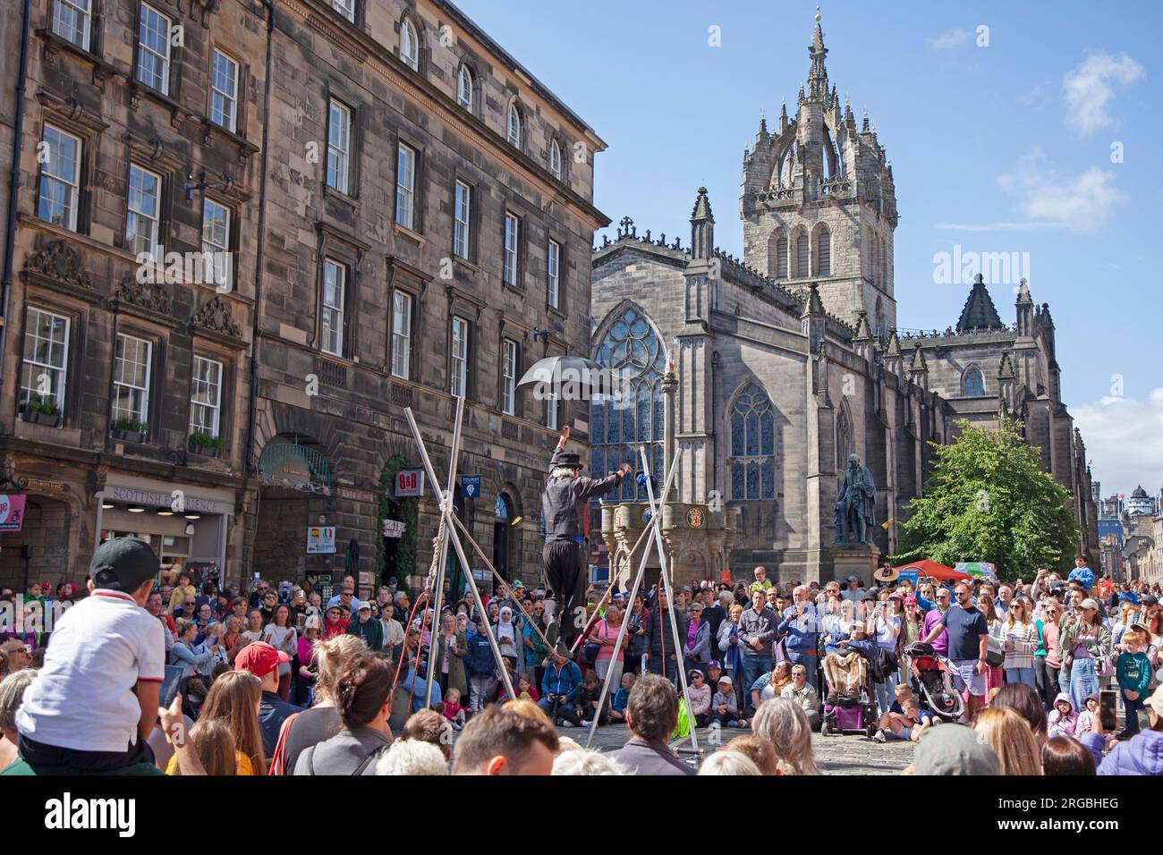 Royal Mile, Edinburgh, Scotland, UK. Busy day at Edinburgh Fringe Festival, large audiences stopping to watch and be entertained by Street Performers on the High Street, helped by the sunshine and warmer weather. Pictured crowds watch Kwabana Lindsay professional street performer. Credit: Archwhite/alamy live news. Stock Photo