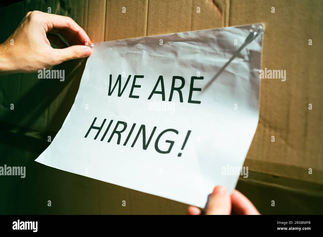 Pinning hiring sign on a wall Stock Photo