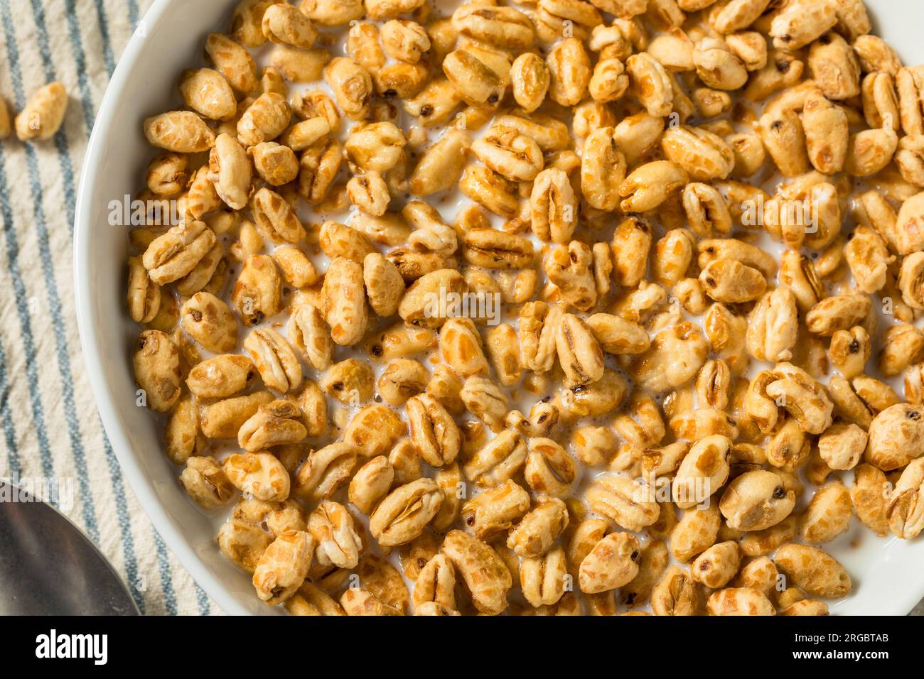 Healthy Sweet Puffed Wheat Breakfast Cereal and Whole Milk Stock Photo