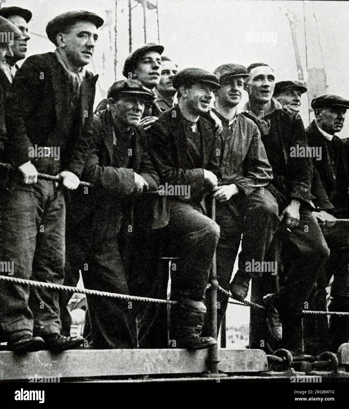 Workers down tools to watch RMS Queen Mary making her way down the River Clyde Stock Photo