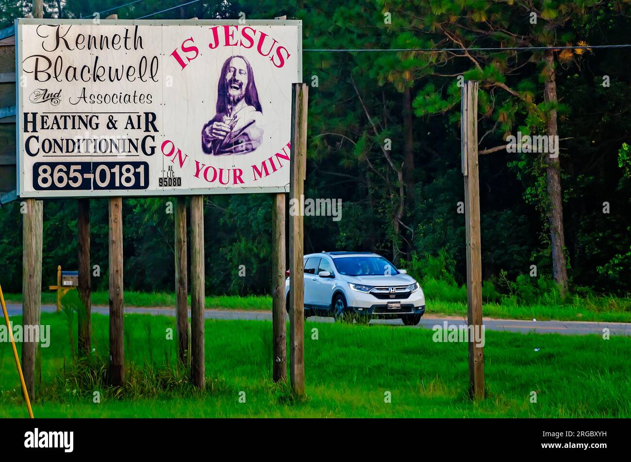 A religious message and picture of Jesus accompany an advertisement for a local repair service, Aug. 4, 2023, in Grand Bay, Alabama. Stock Photo