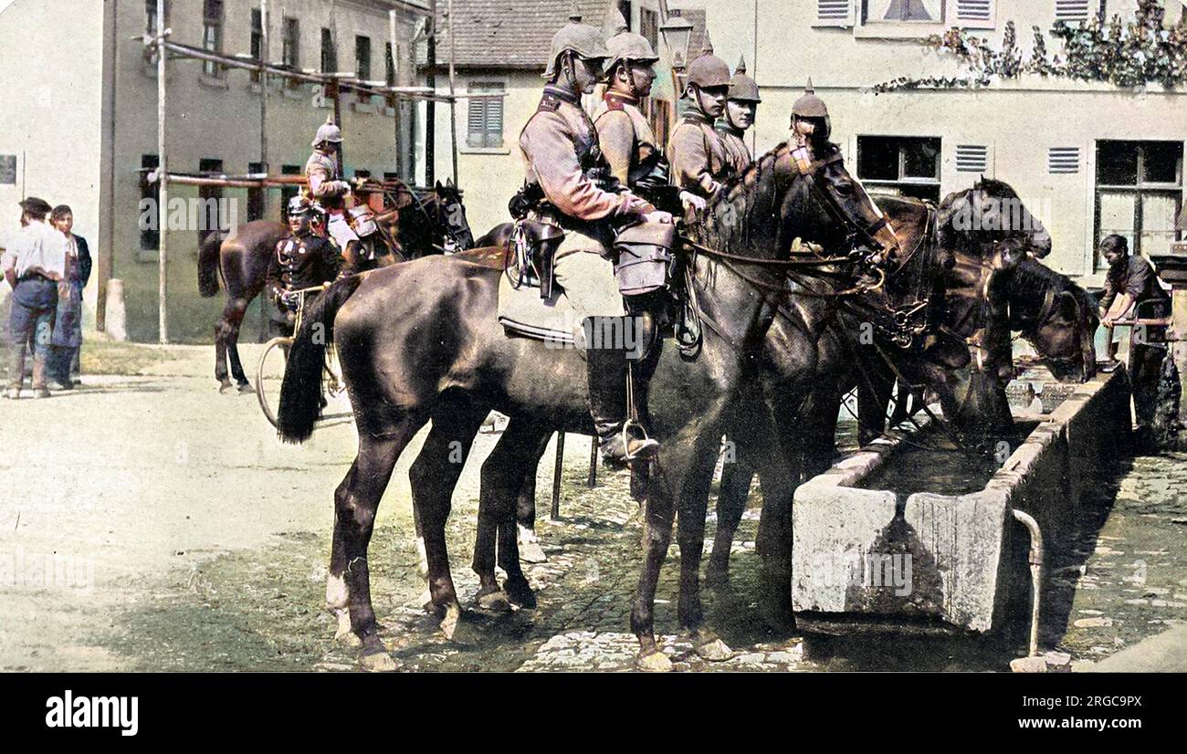German cavalry officers in August 1914, complete with helmets, water their horses at a trough