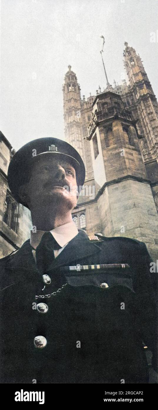 On guard beneath the Victoria Tower is the custodian, Ronald Foyle. Parliamentary custodians supplement the security of the Palace of Westminster; they were formed in 1932 following the Geddes Parliamentary Report which drastically cut the number of regular police assigned to Parliament. Stock Photo
