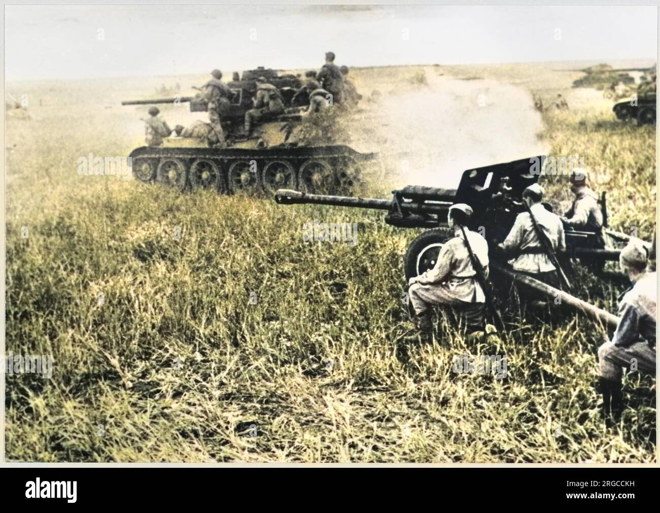 A Soviet T-34 tank passing a 76.2mm field gun. Stock Photo