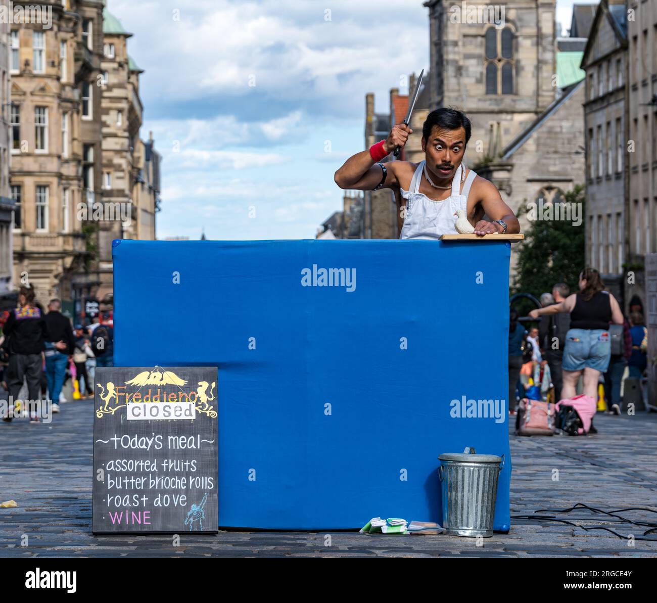 Royal Mile, Edinburgh, Scotland, UK, 8th August 2023. Edinburgh Fringe street performers: FreddieNo, a Freddie Mercury Queen street performer entertains the passing crowds with a slapstick show. Credit: Sally Anderson/Alamy Live News Stock Photo