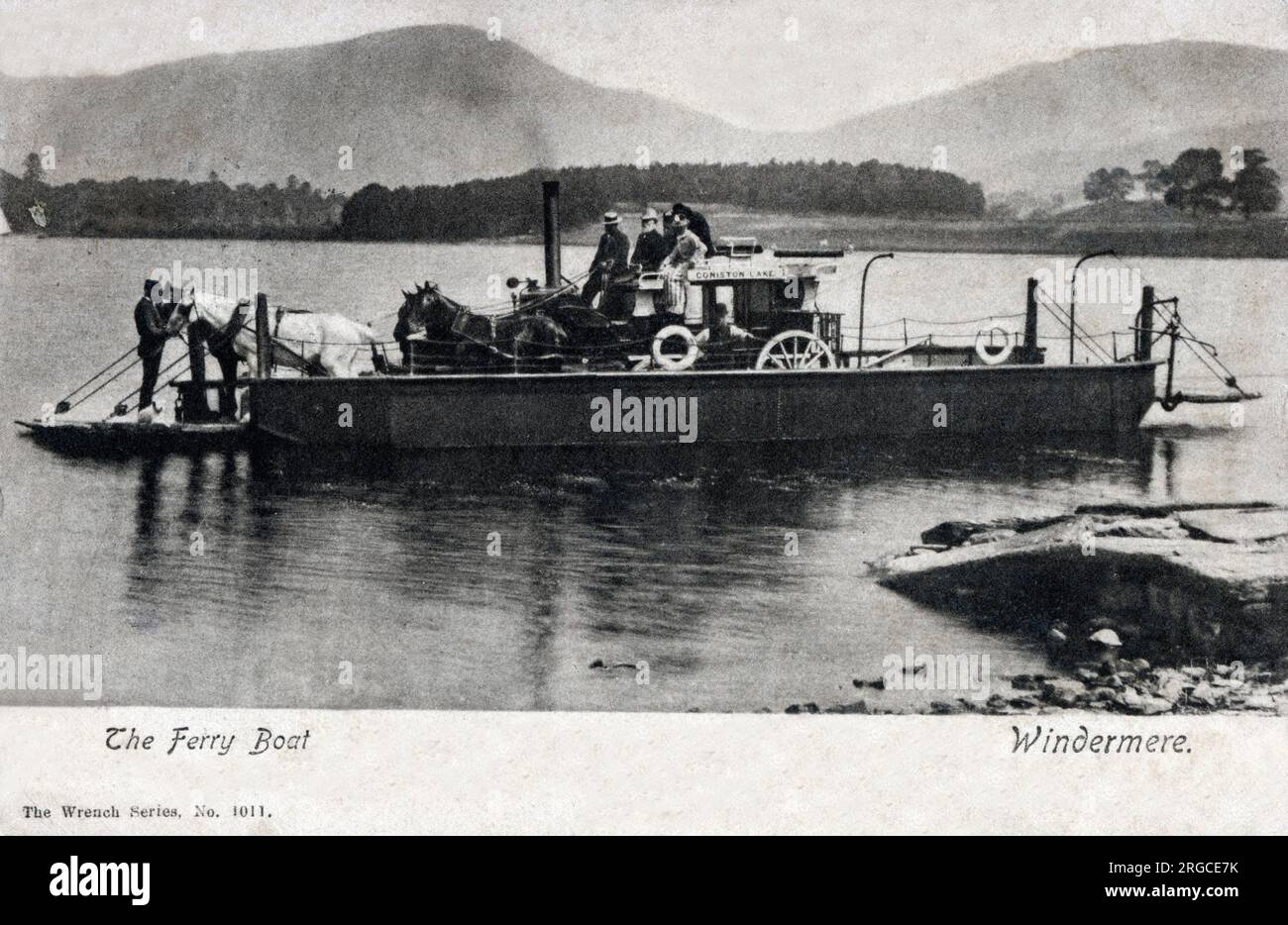 The departing Bowness Ferry boat on the way to Furness Abbey, transporting a horse-drawn carriage across Lake Windermere, Lake District, Cumbria. Stock Photo