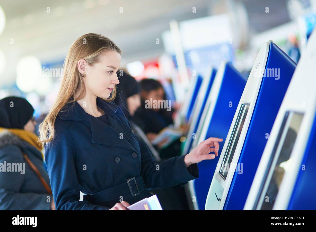 Young woman in international airport doing self check-in Stock Photo ...