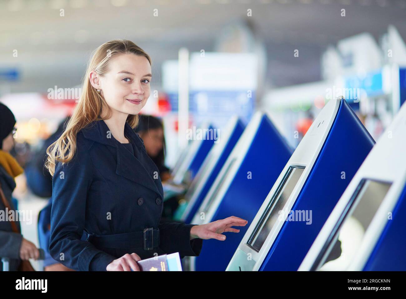 Young woman in international airport doing self check-in Stock Photo ...