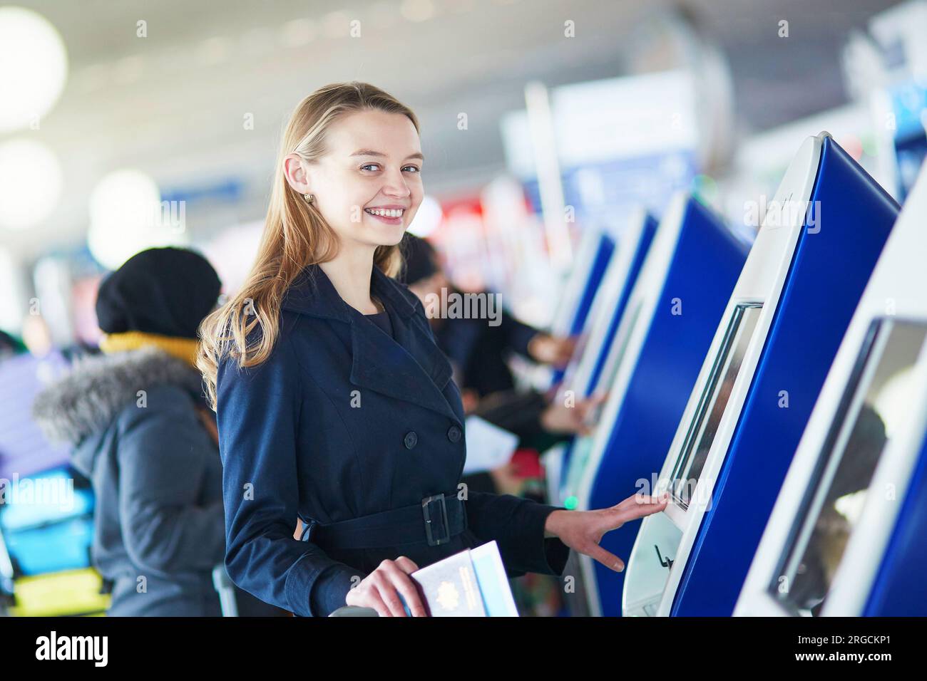 Young woman in international airport doing self check-in Stock Photo ...