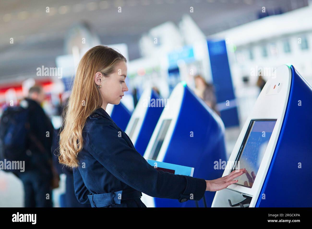 Young woman in international airport doing self check-in Stock Photo ...