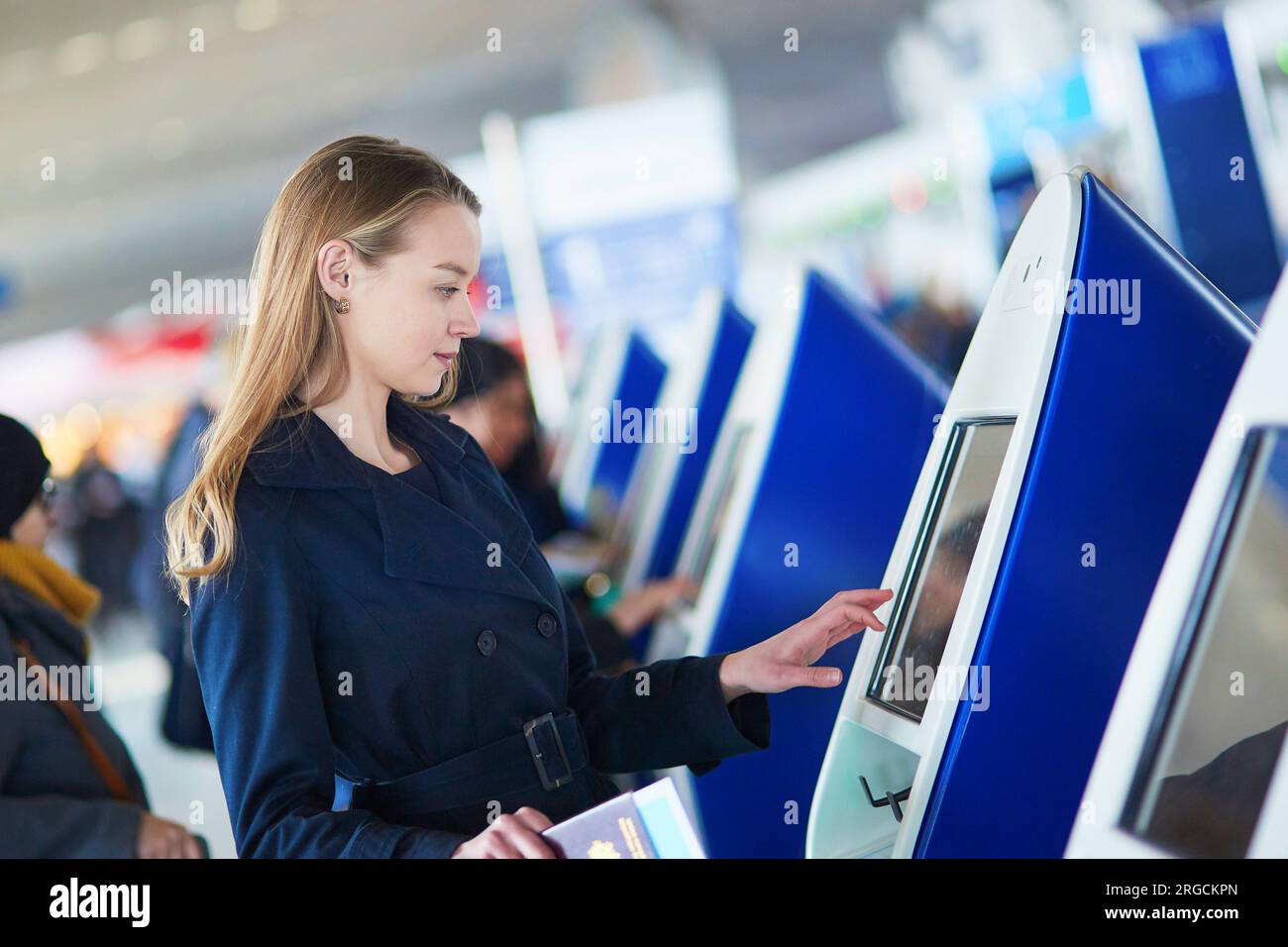 Young woman in international airport doing self check-in Stock Photo ...