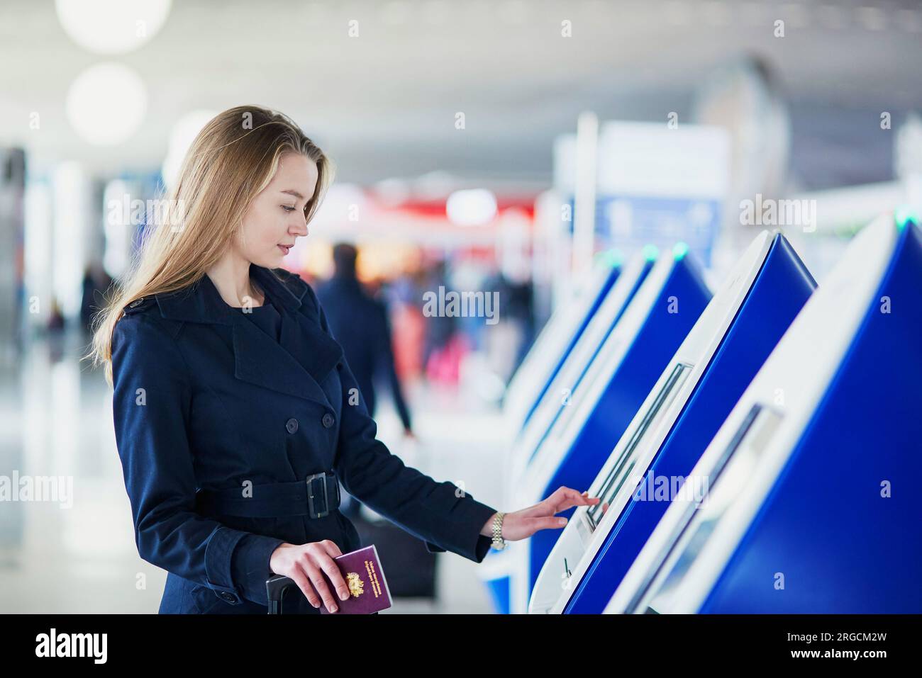 Young woman in international airport doing self check-in Stock Photo ...