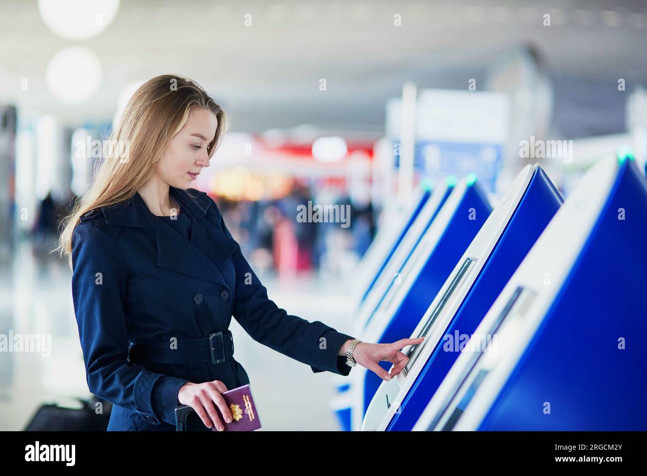 Young woman in international airport doing self check-in Stock Photo ...