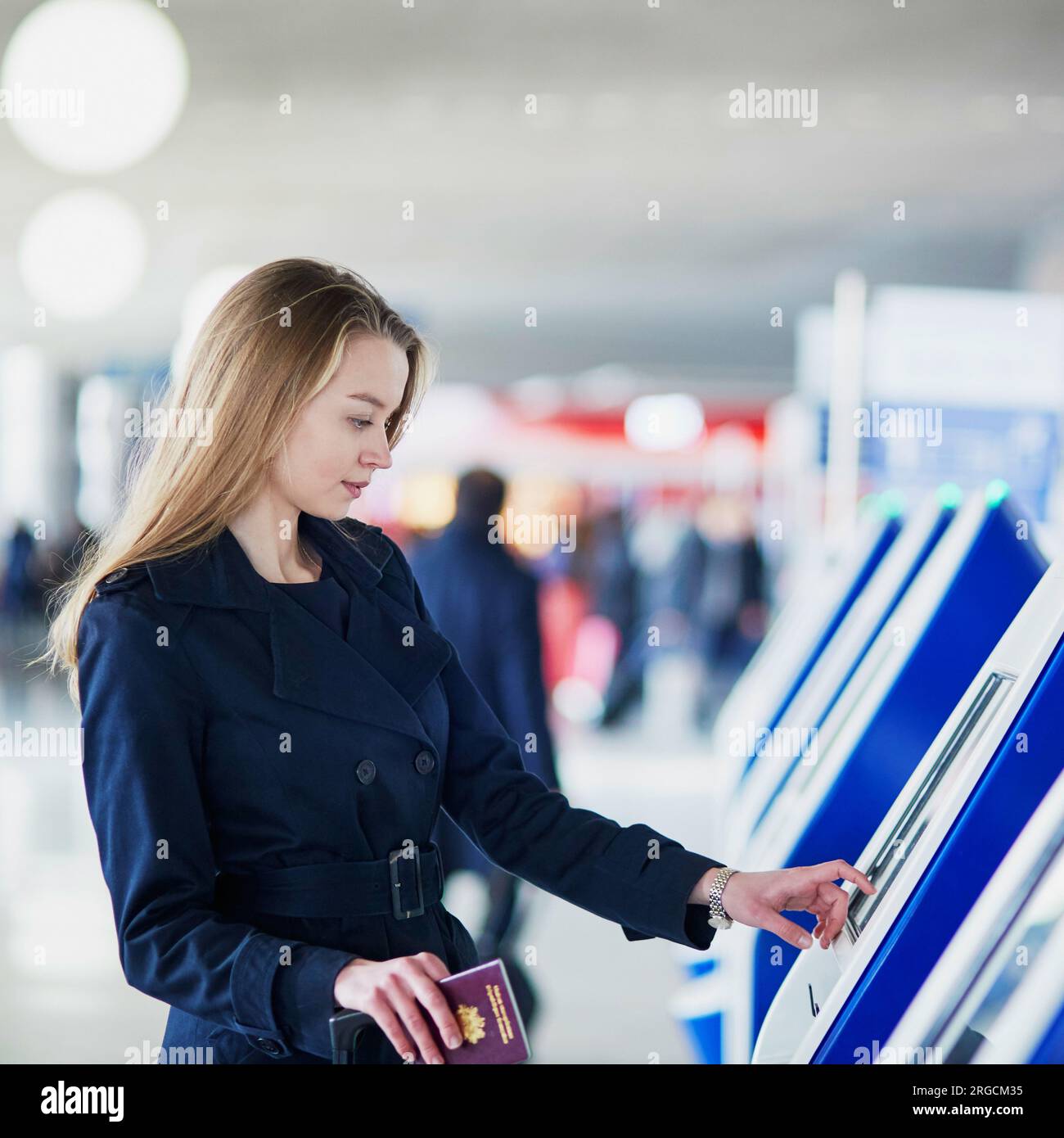 Young woman in international airport doing self check-in Stock Photo ...