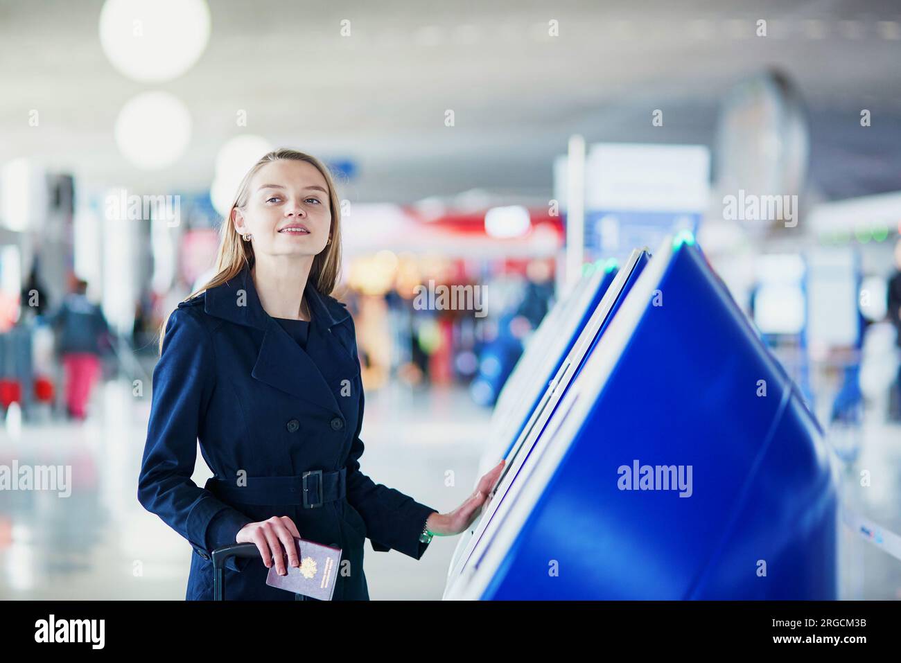 Young woman in international airport doing self check-in Stock Photo ...