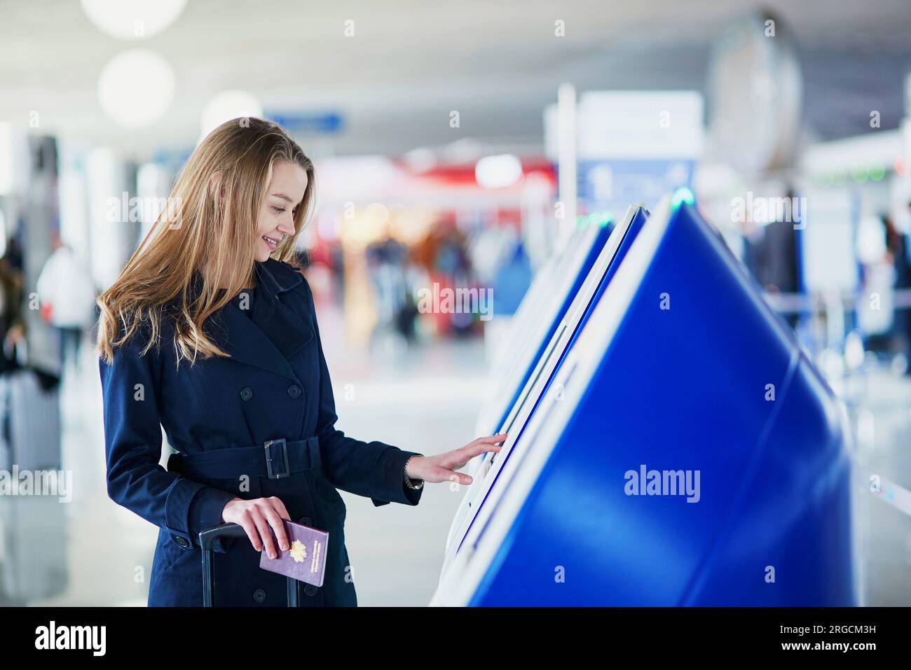 Young woman in international airport doing self check-in Stock Photo ...
