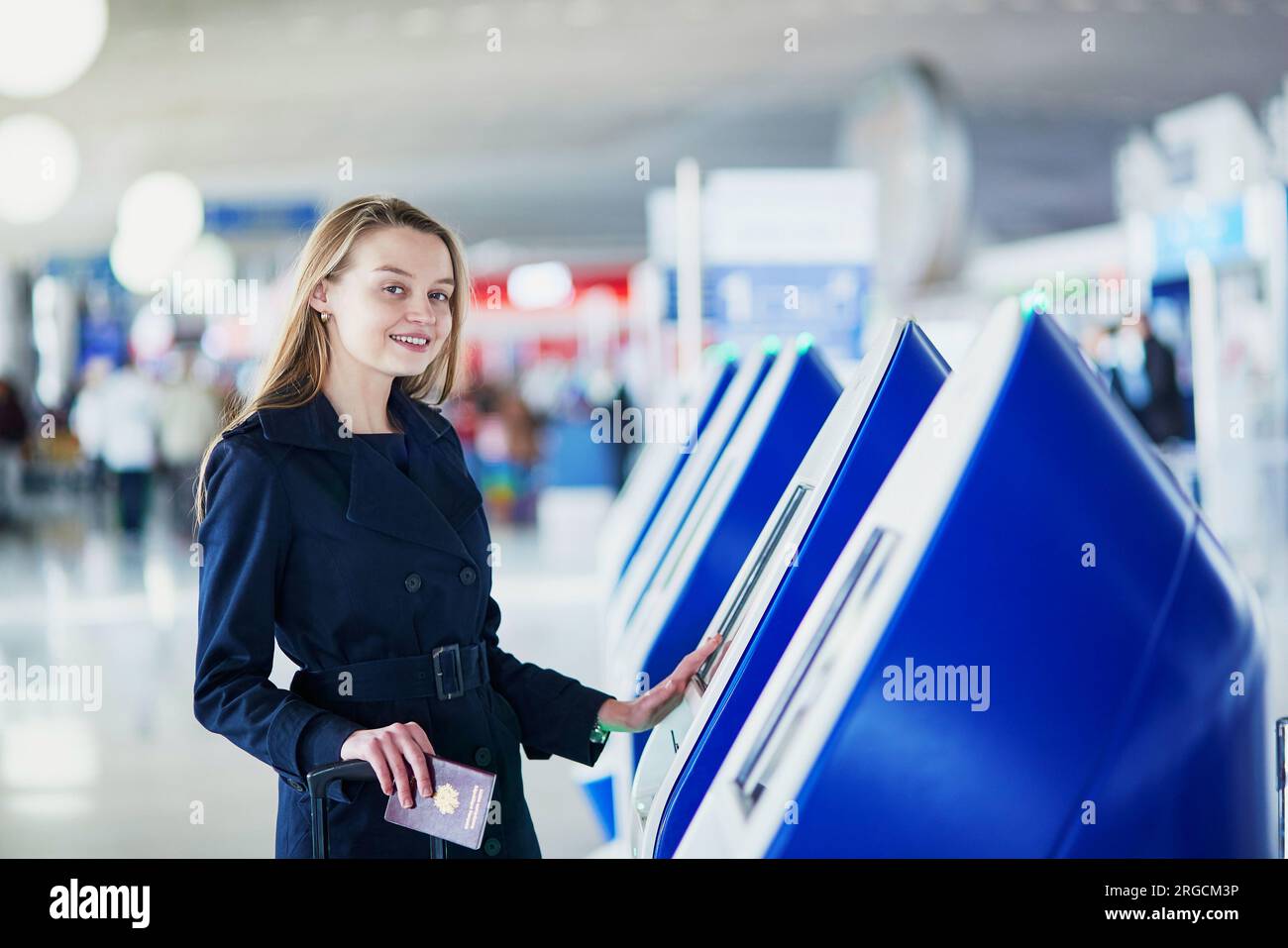 Young woman in international airport doing self check-in Stock Photo ...