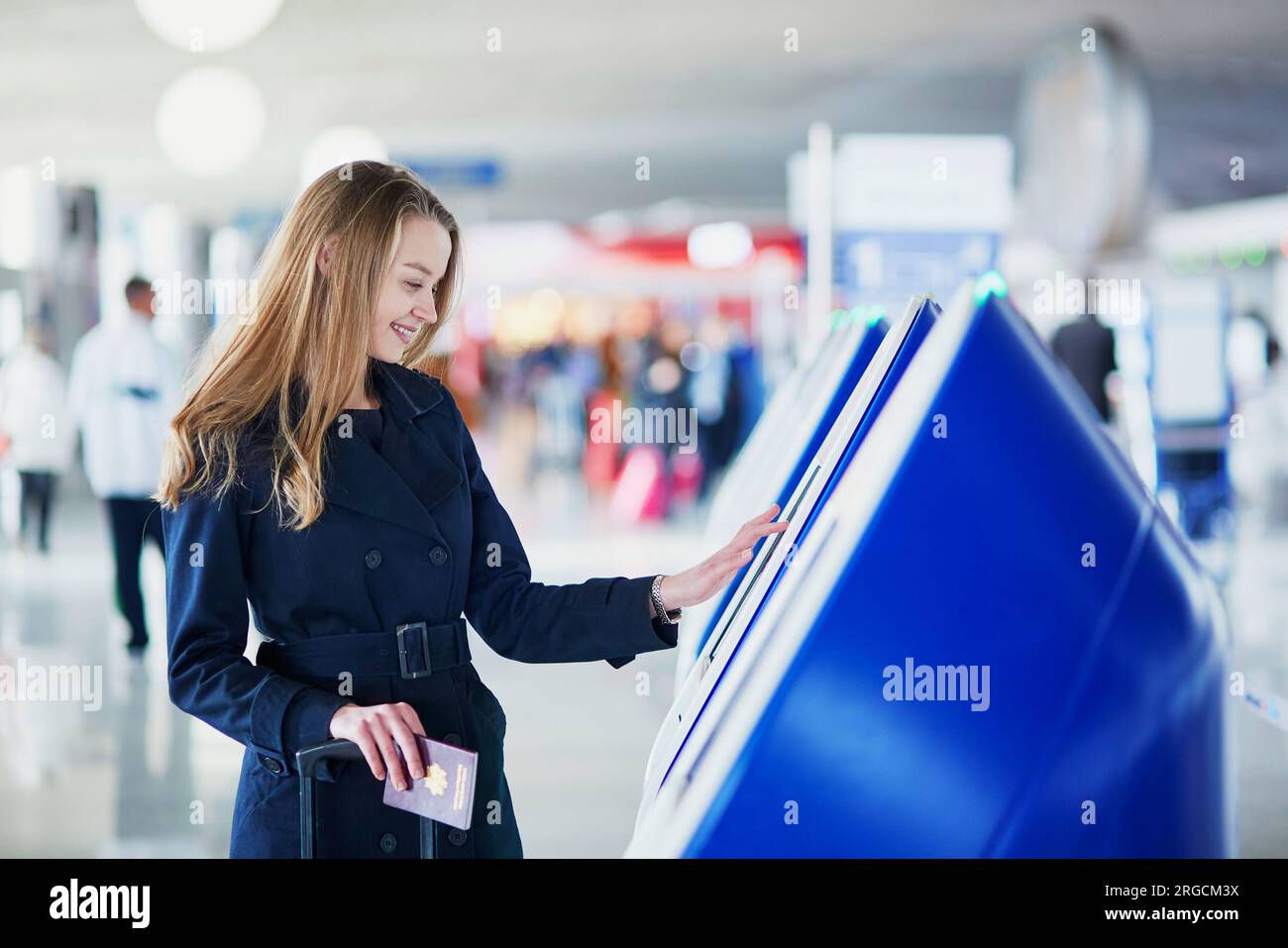 Young woman in international airport doing self check-in Stock Photo ...