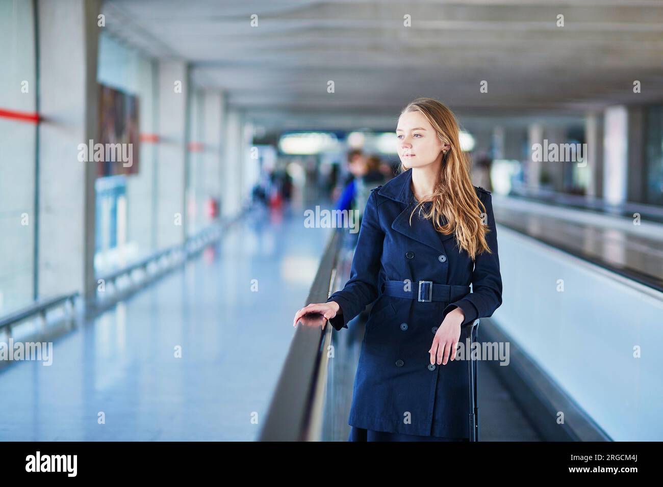 Young woman in international airport walking along the travelator Stock ...