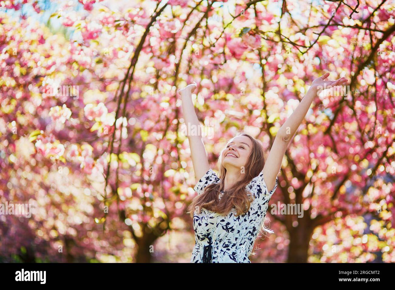 Beautiful girl in cherry blossom garden on a spring day Stock Photo - Alamy