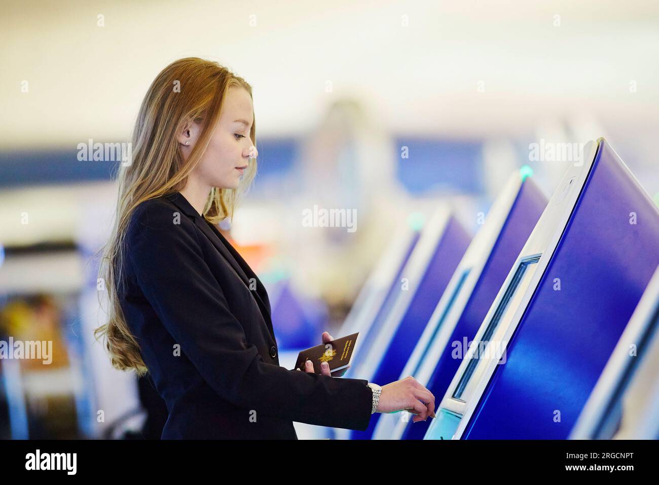 Young woman in international airport doing self check-in Stock Photo ...
