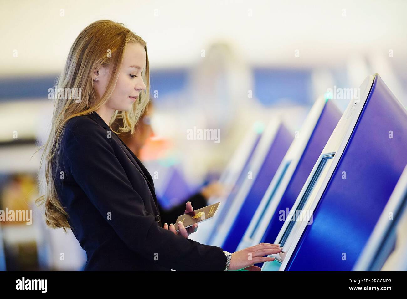 Young woman in international airport doing self check-in Stock Photo ...