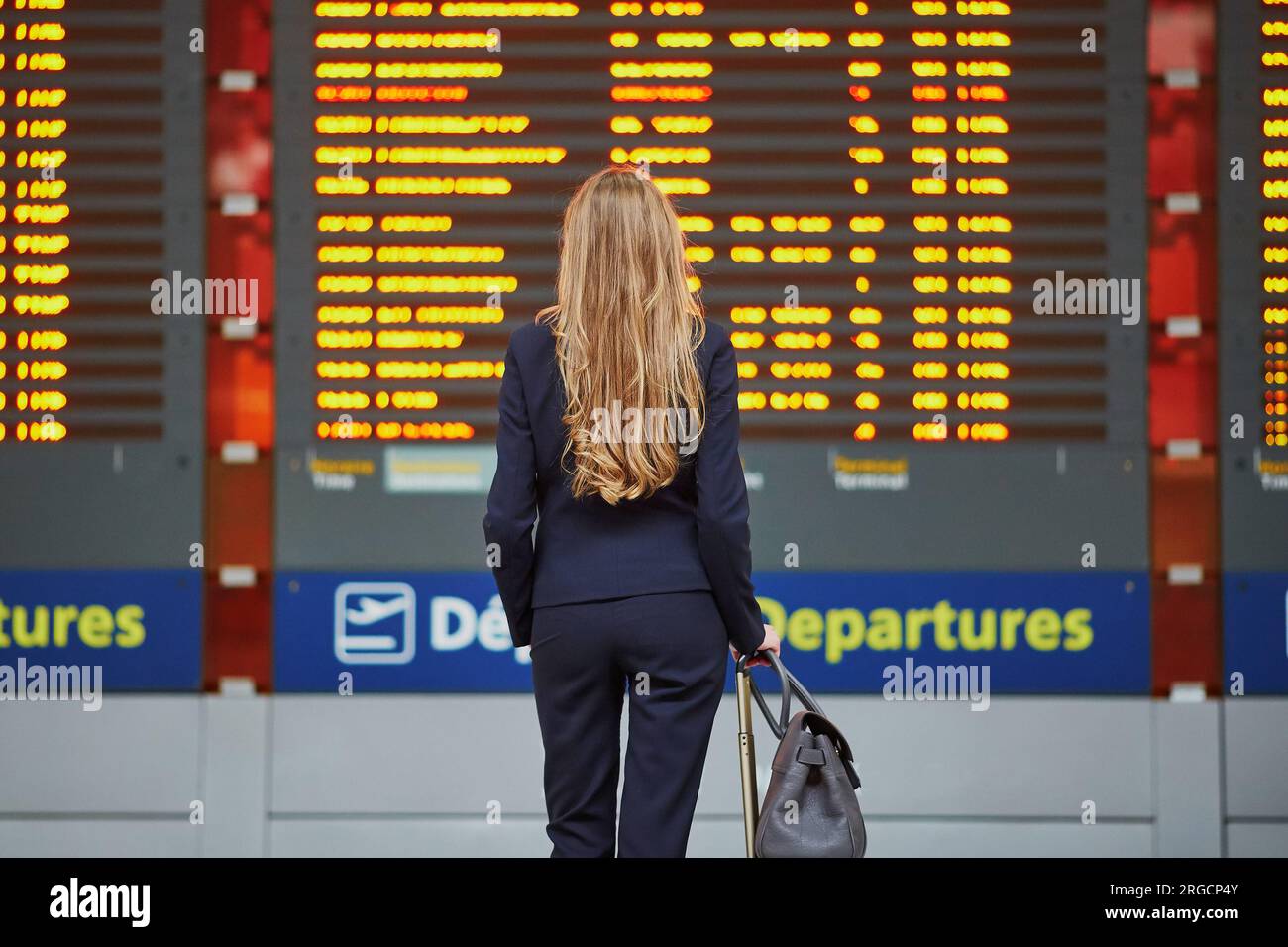 Young elegant business woman with hand luggage in international airport