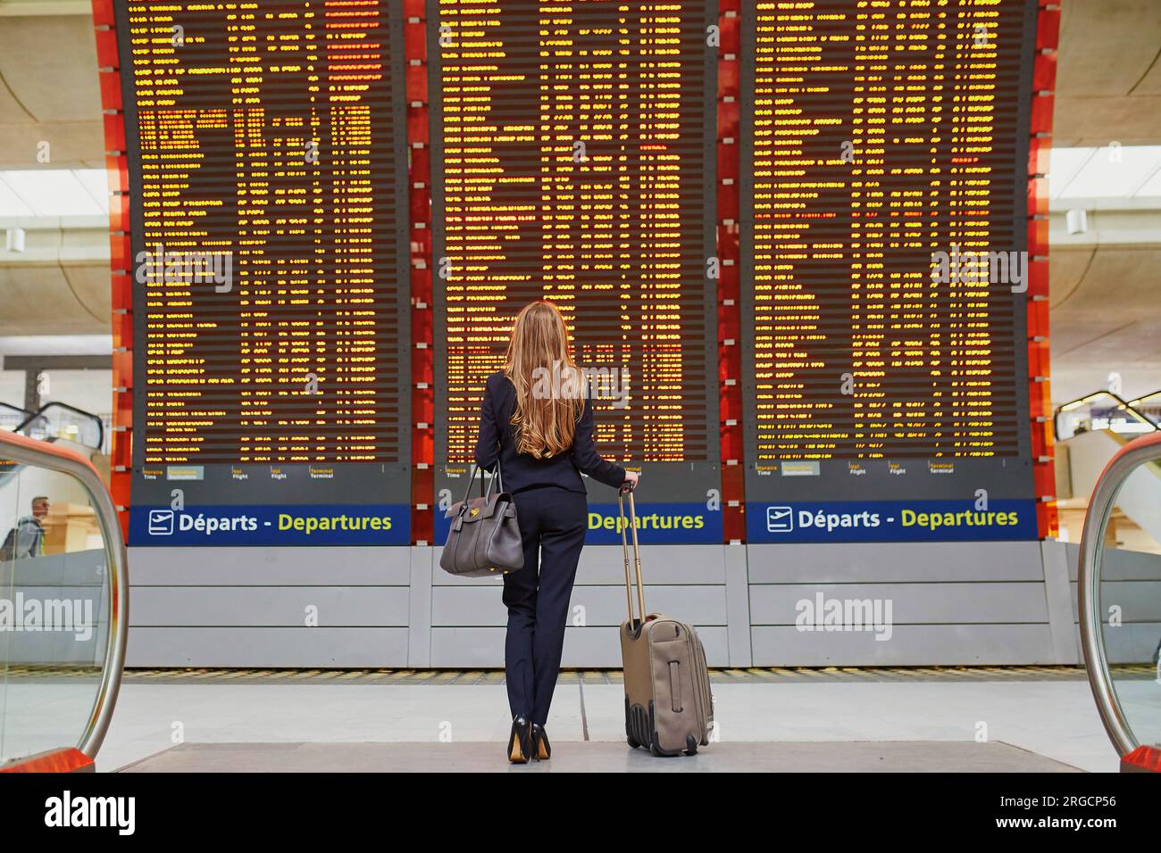 Young elegant business woman with hand luggage in international airport