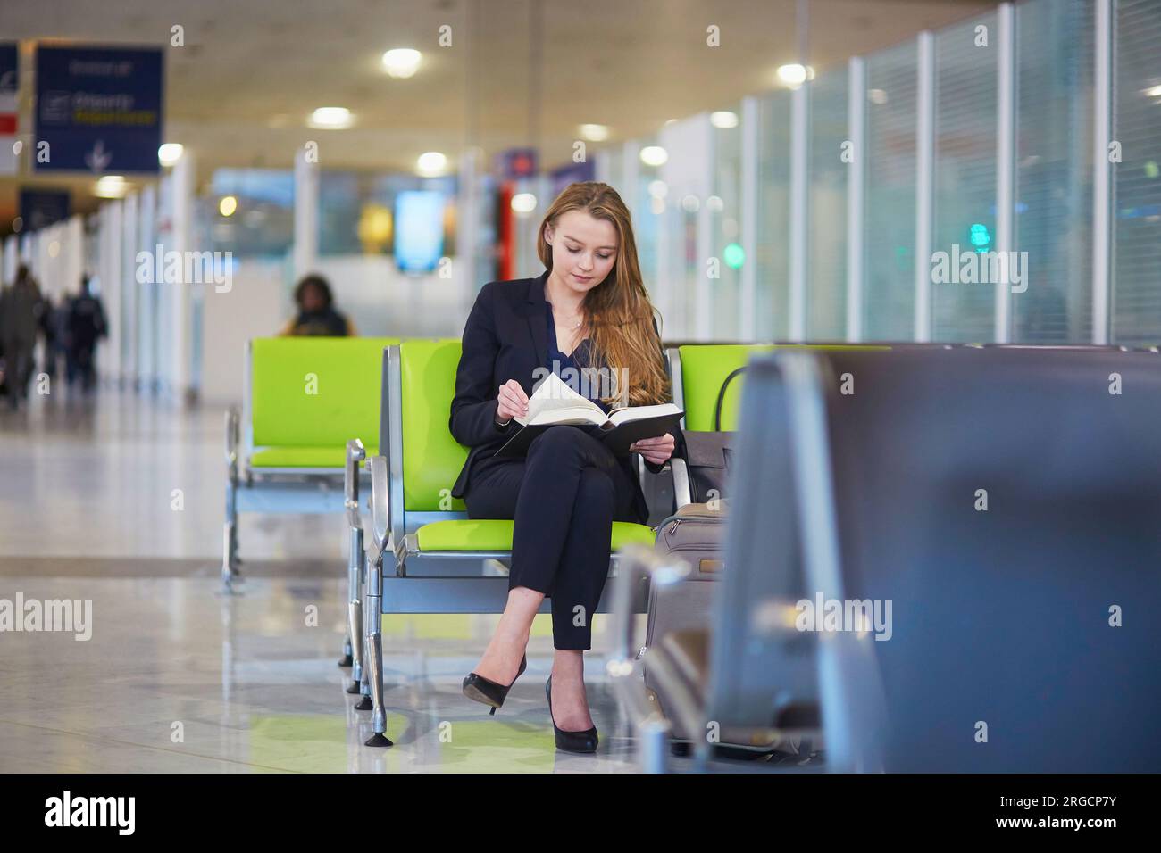 Young elegant business woman with hand luggage in international airport