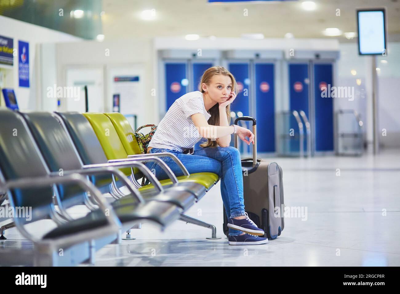 Young woman in international airport waiting for her flight Stock Photo ...