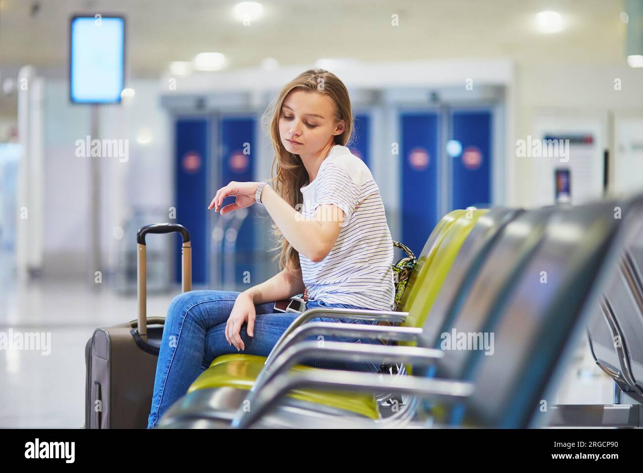 Young woman in international airport waiting for her flight Stock Photo ...