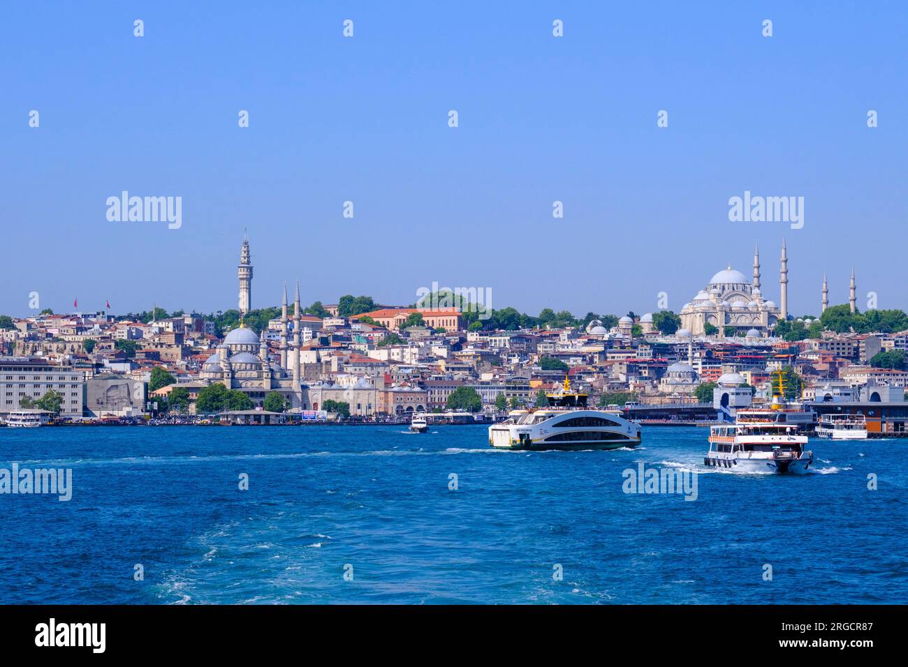 Istanbul, Turkey, Türkiye. Commuter Ferries on the Golden Horn. Suleymaniye Mosque in background on right; New Mosque (Yeni Camii) in foreground left. Stock Photo