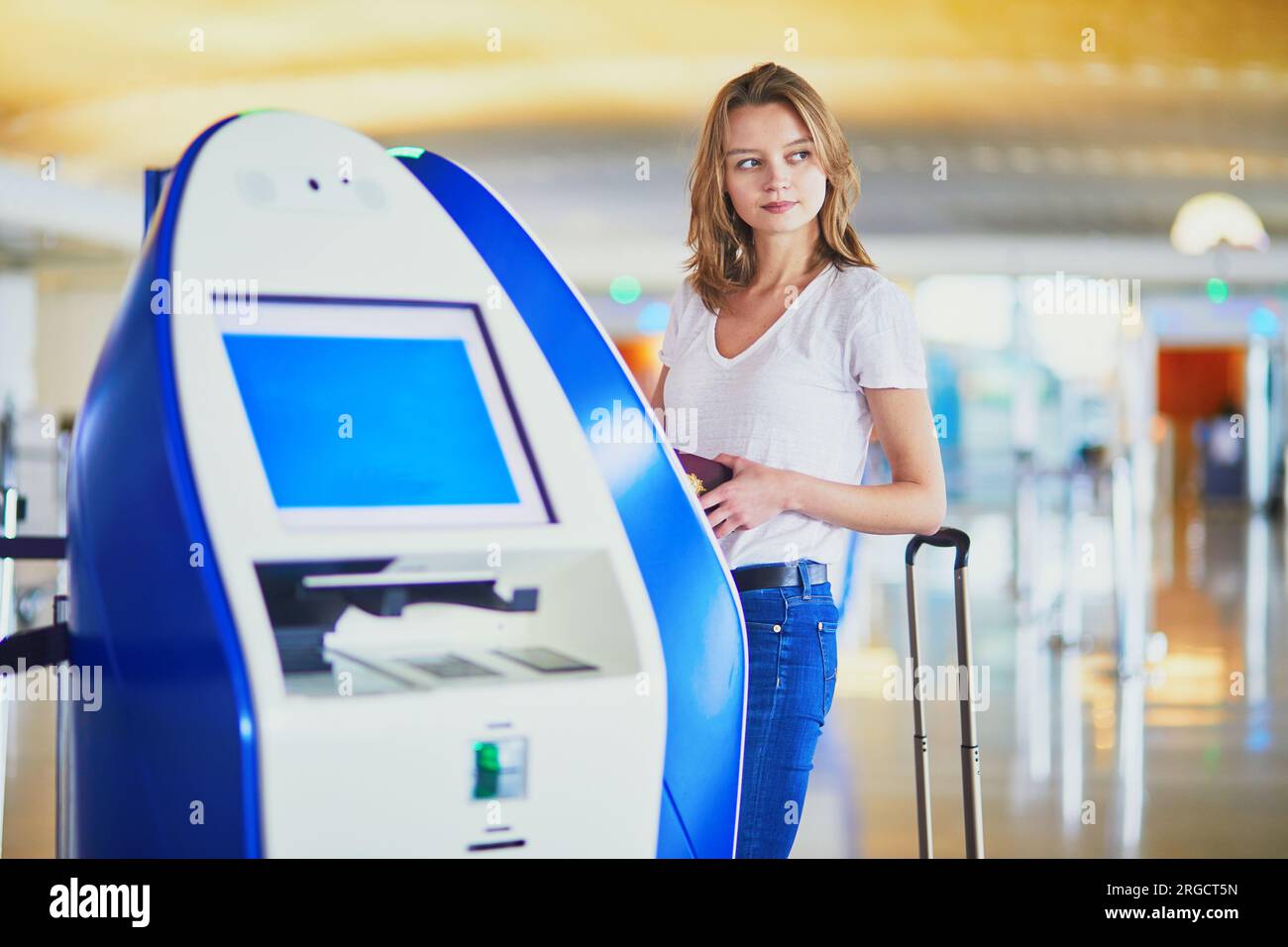 Young woman in international airport doing self check-in Stock Photo ...