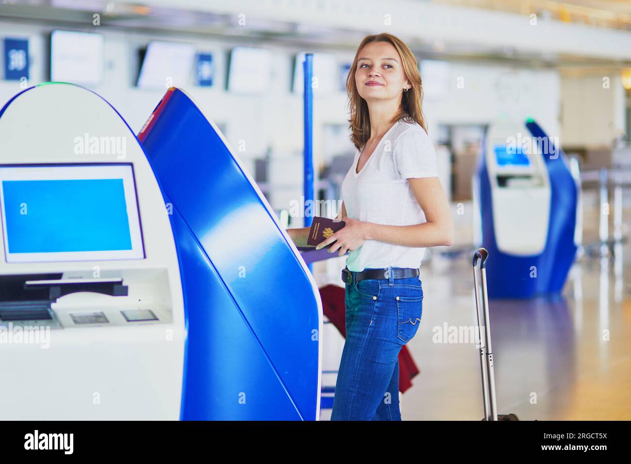 Young woman in international airport doing self check-in Stock Photo ...