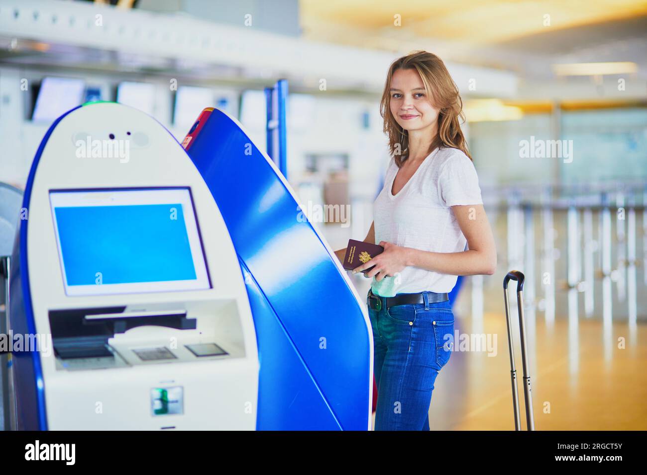 Young woman in international airport doing self check-in Stock Photo ...