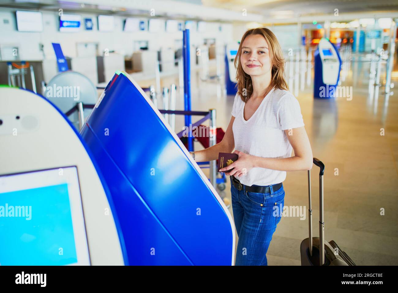 Young woman in international airport doing self check-in Stock Photo ...