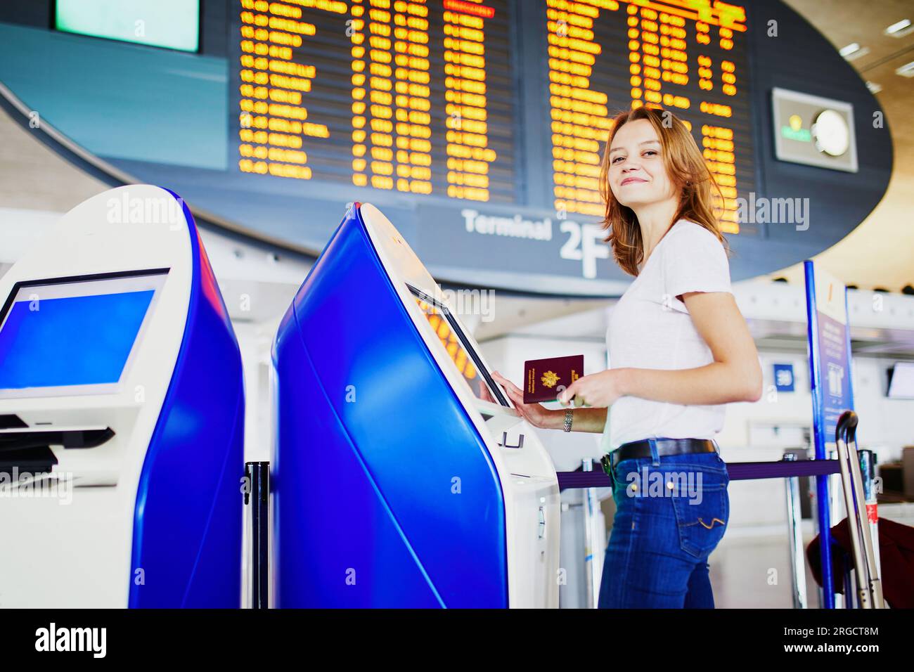 Young woman in international airport doing self check-in Stock Photo ...