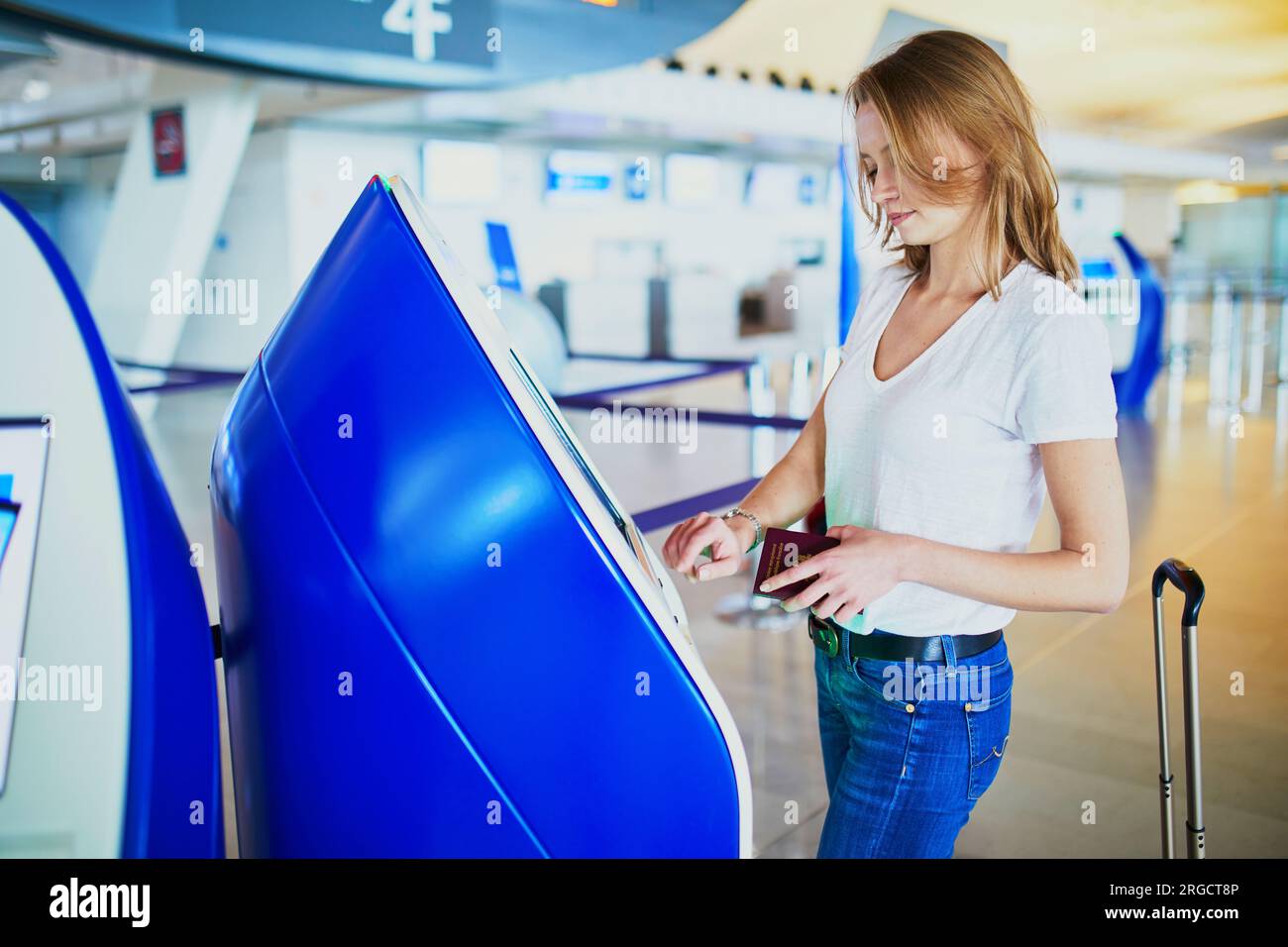 Young woman in international airport doing self check-in Stock Photo ...