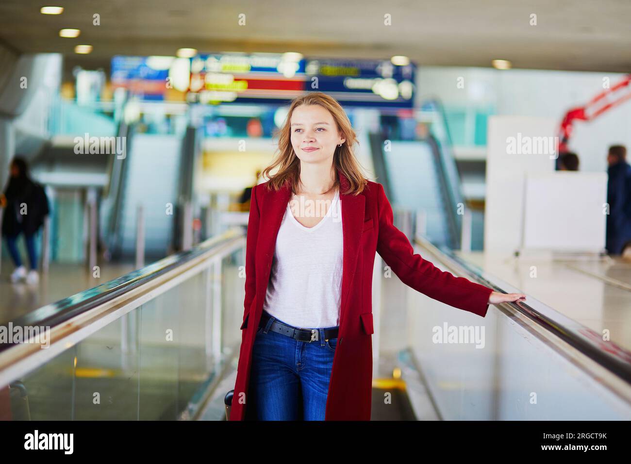 Young woman in international airport with luggage on travelator Stock ...