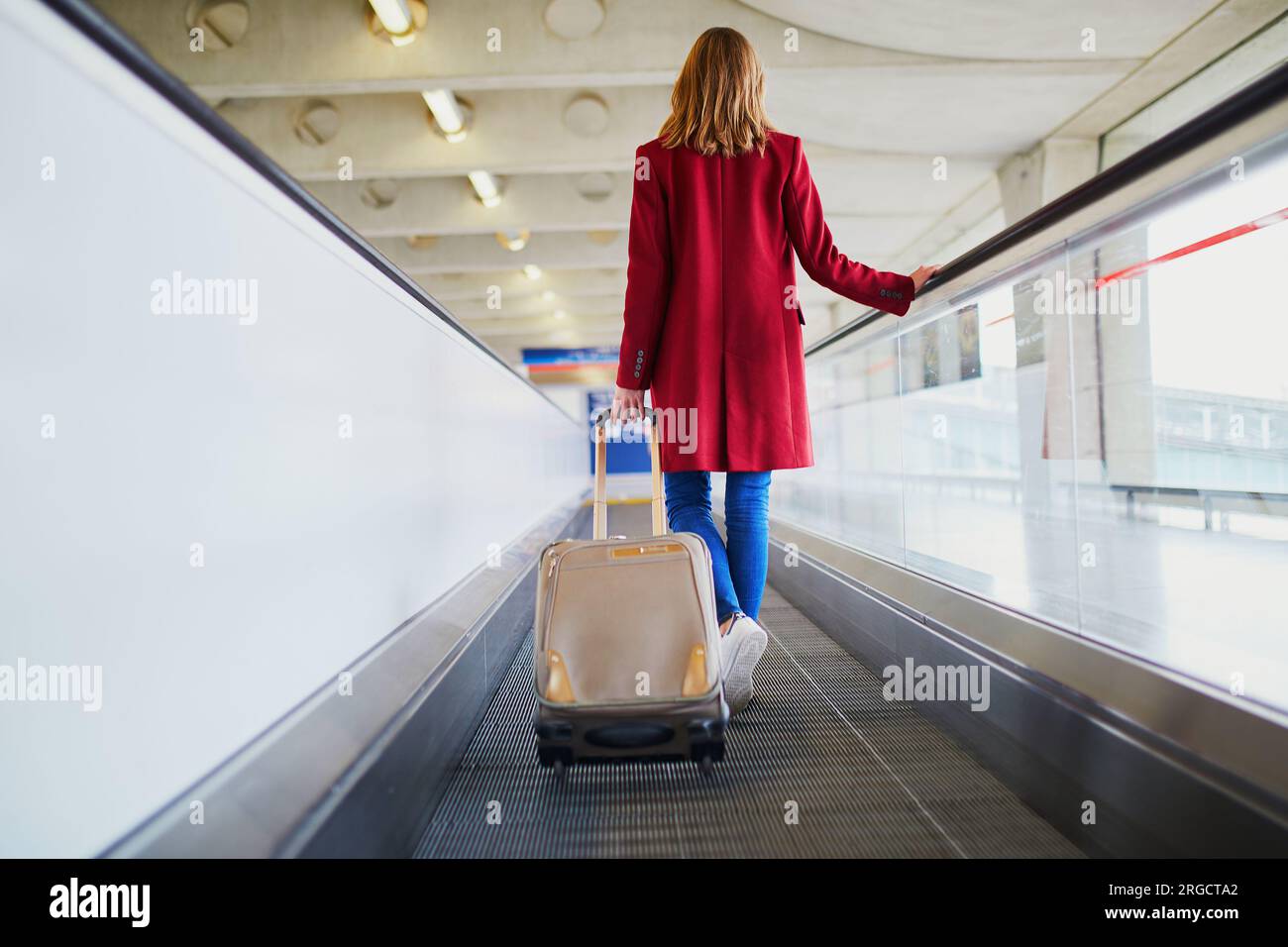 Young woman in international airport with luggage on travelator Stock ...