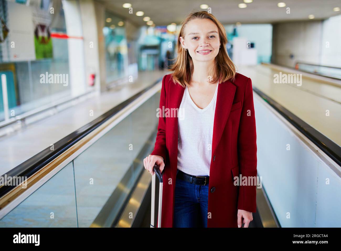 Young woman in international airport with luggage on travelator Stock ...