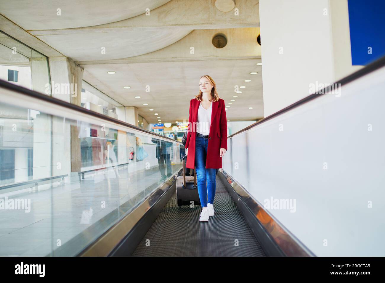 Young woman in international airport with luggage on travelator Stock ...