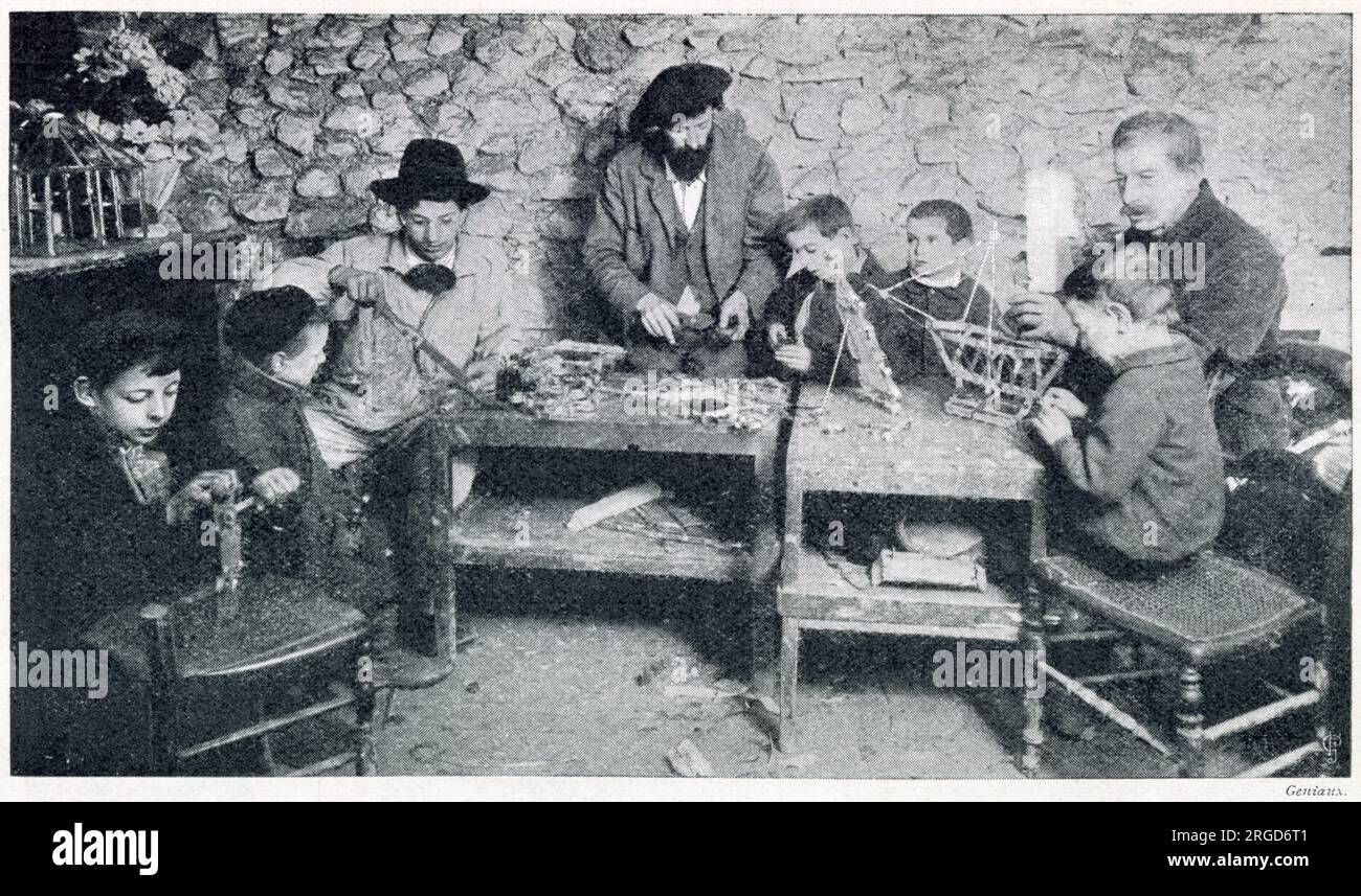 A group of young boys been instructed how to make toys from tin in Paris. Stock Photo