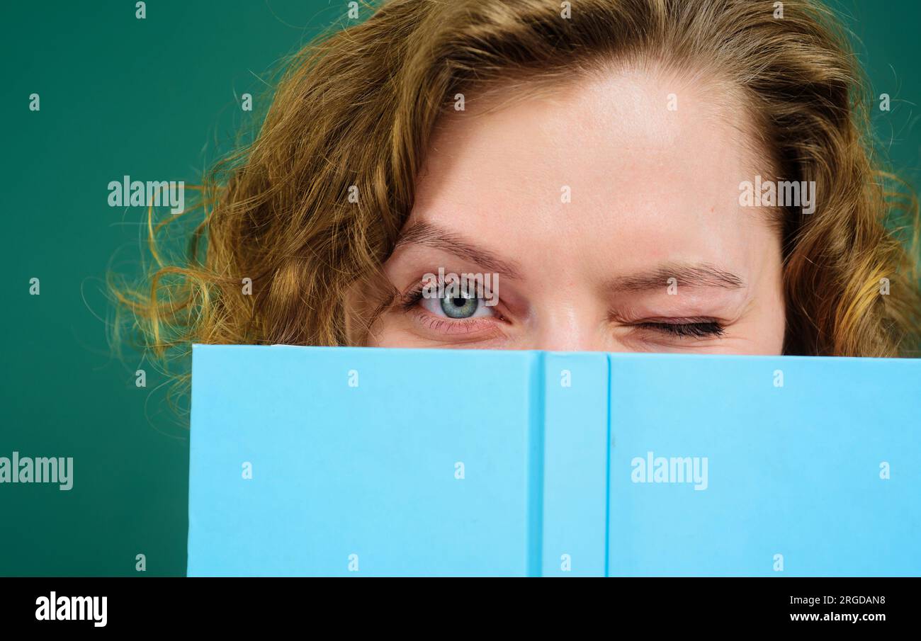Close up portrait of winking teacher with notepad. School supplies