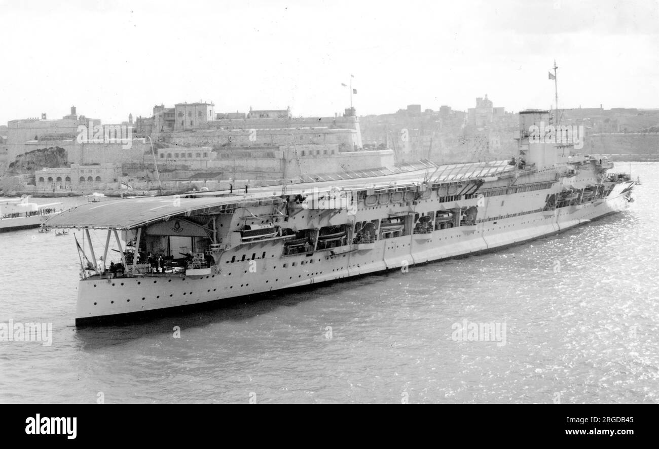 Royal Navy - HMS Glorius, aircraft carrier, at anchor, steaming up. HMS Glorious was the second of the three Courageous-class battlecruisers built for the Royal Navy during the First World War. Designed to support the Baltic Project championed by the First Sea Lord, Lord Fisher, they were relatively lightly armed and armoured. Glorious was completed in late 1916 and spent the war patrolling the North Sea. She participated in the Second Battle of Heligoland Bight in November 1917 and was present when the German High Seas Fleet surrendered a year later.  Glorious was paid off after the war, but Stock Photo